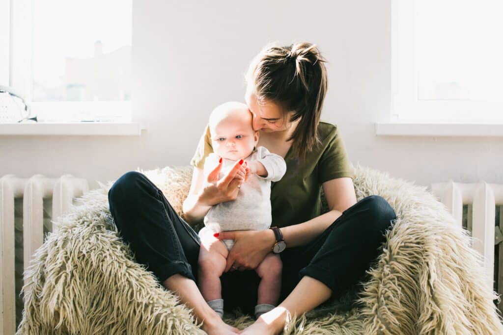 A 13-year old babysitter holding the baby